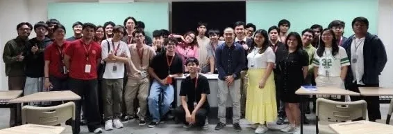 The whole bootcamp cohort standing together at the front of a classroom, several dozen students in rows.