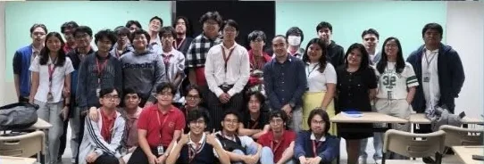 A second group photo, with one row of participants crouched in front and the rest standing behind.